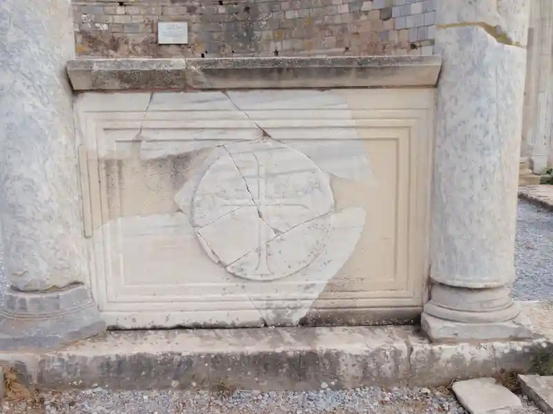 Solar cross in the ruins of the Ancient Church of Mary. The cross is on what appears to be marble in between two pillars.